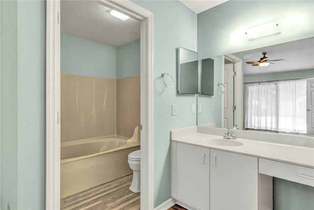 full bathroom featuring wood-type flooring, vanity, shower / tub combination, toilet, and ceiling fan