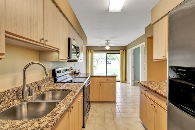 kitchen featuring stainless steel appliances, light brown cabinetry, light stone countertops, and sink