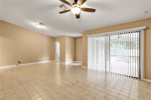 spare room with ceiling fan and light tile patterned floors