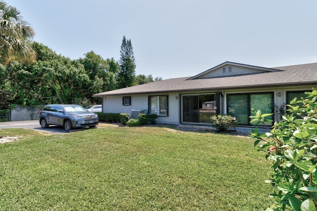 ranch-style home with cooling unit and a front yard