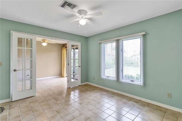 spare room featuring french doors, a healthy amount of sunlight, and light tile patterned floors