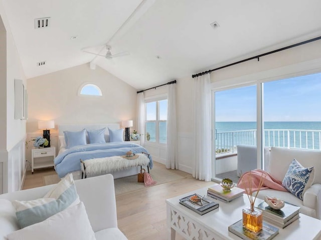 bedroom with a water view, light hardwood / wood-style floors, and vaulted ceiling with beams