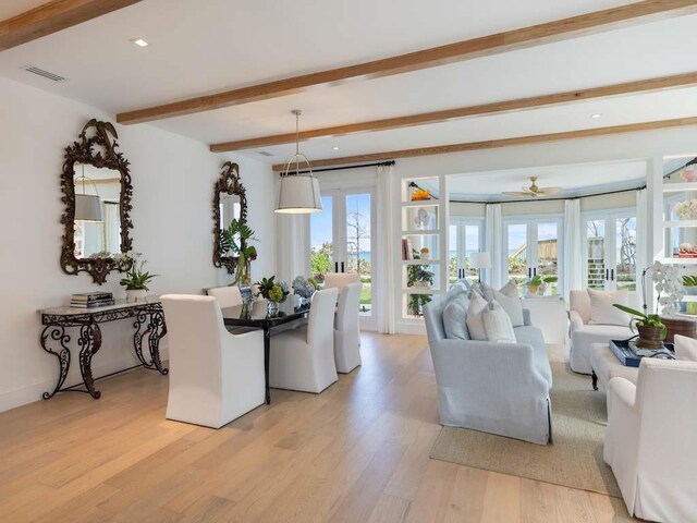 living room featuring beamed ceiling and light wood-type flooring