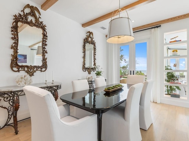 dining area with beamed ceiling and light hardwood / wood-style floors