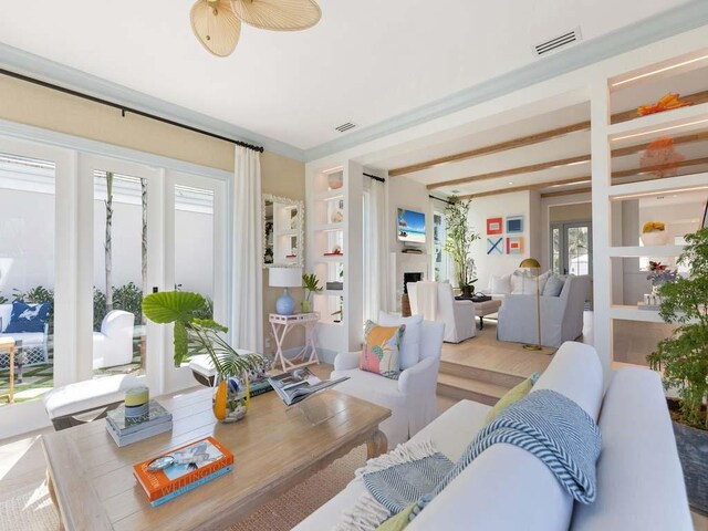 dining area featuring a fireplace, light hardwood / wood-style floors, french doors, and beamed ceiling