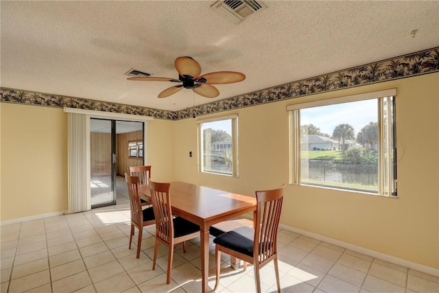 tiled dining area featuring a textured ceiling and ceiling fan