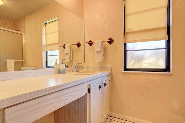 bathroom featuring a shower with door, vanity, and tile patterned floors