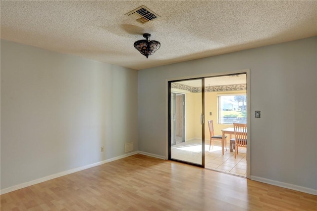 empty room featuring a textured ceiling and light wood-type flooring