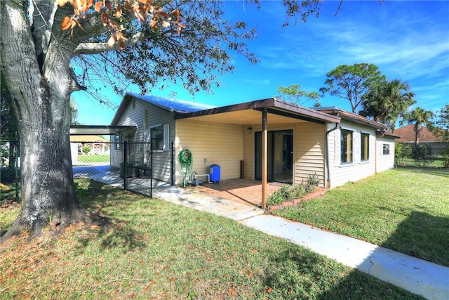 rear view of house with a yard and a carport