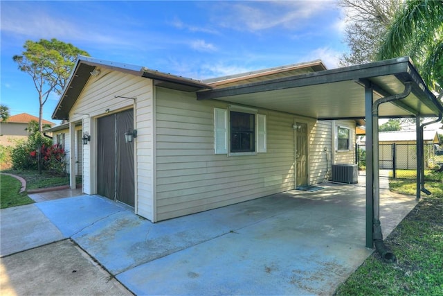 view of side of home with a garage and central AC