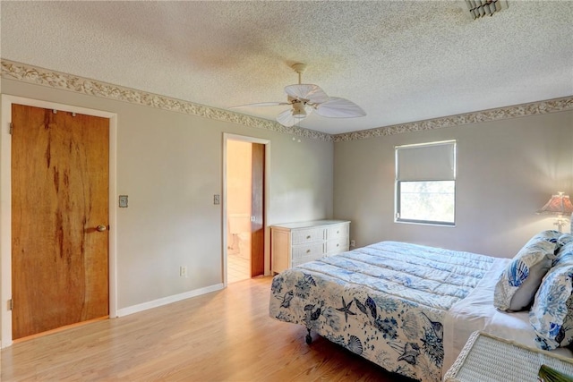 bedroom featuring ceiling fan, light hardwood / wood-style floors, and a textured ceiling