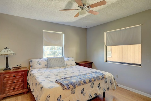 bedroom with wood-type flooring, ceiling fan, and a textured ceiling