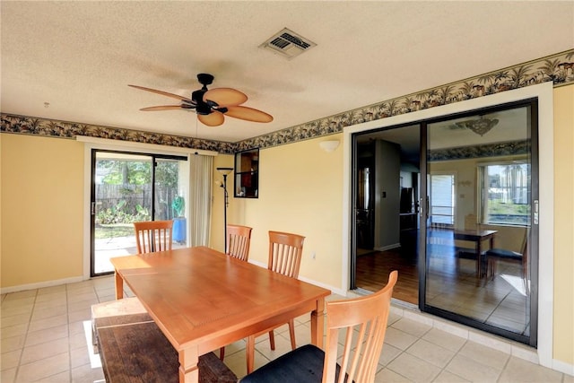 dining room featuring light tile patterned flooring, ceiling fan, and a textured ceiling