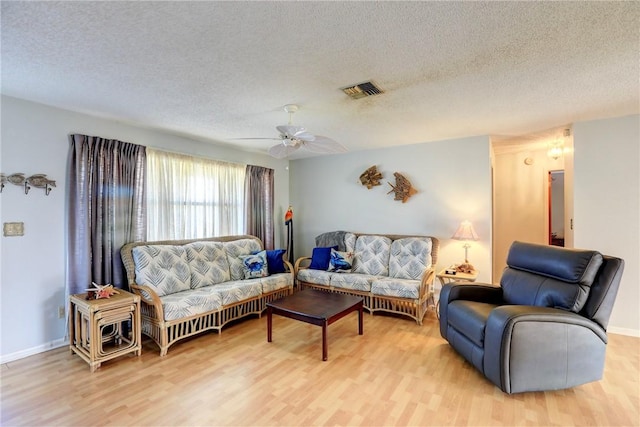 living room with a textured ceiling and light hardwood / wood-style floors