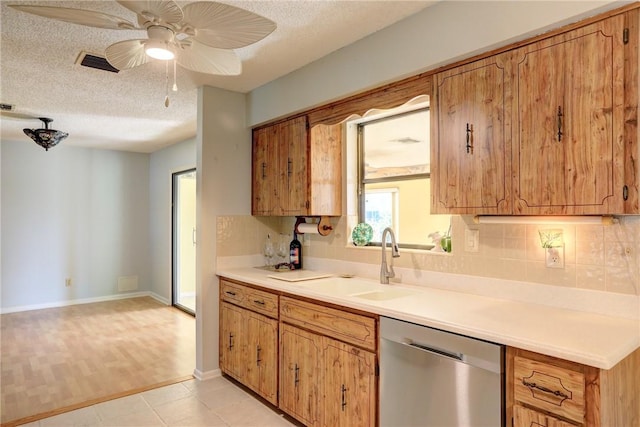 kitchen featuring sink, decorative backsplash, stainless steel dishwasher, and a textured ceiling