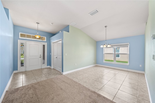 tiled entrance foyer with a chandelier and vaulted ceiling