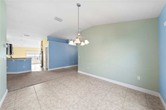 empty room with lofted ceiling and an inviting chandelier