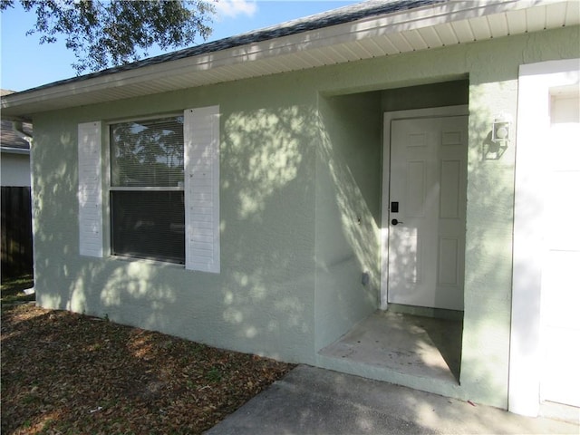 property entrance with stucco siding