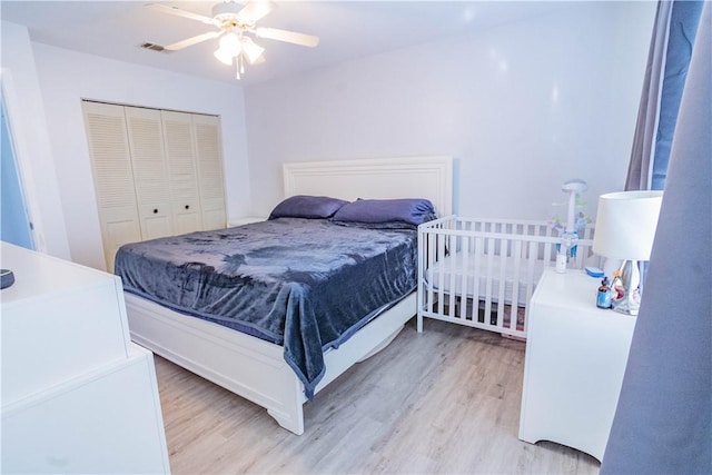 bedroom with ceiling fan, light wood-type flooring, and a closet