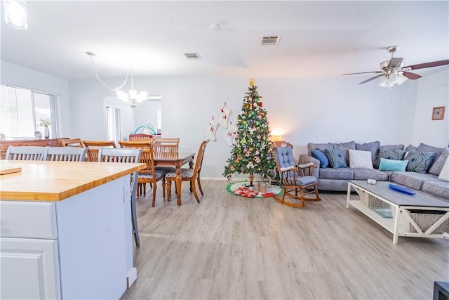 interior space featuring light hardwood / wood-style floors and ceiling fan with notable chandelier