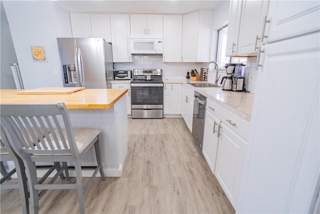 kitchen featuring light hardwood / wood-style floors, sink, white cabinetry, and stainless steel appliances