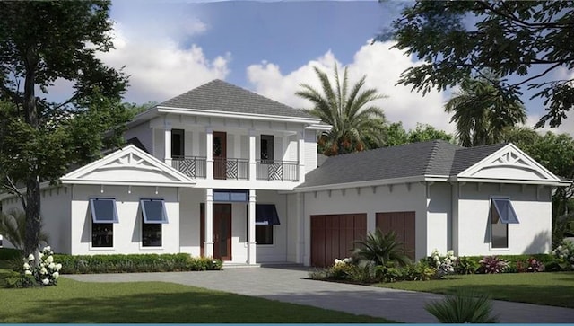 exterior space featuring a balcony, a garage, and a front yard