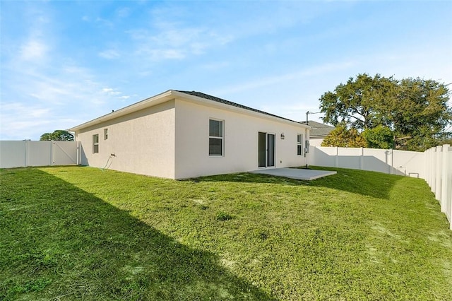 rear view of property featuring a lawn and a patio area