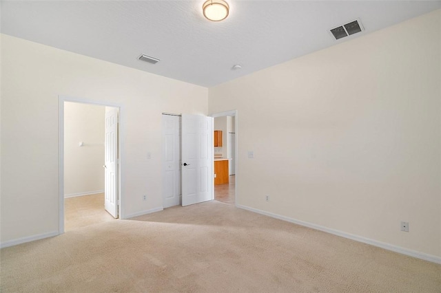 unfurnished bedroom featuring light carpet and a closet