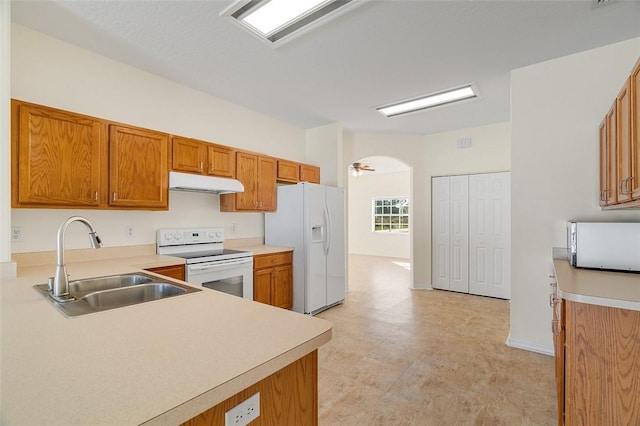 kitchen with sink, white appliances, and kitchen peninsula