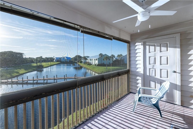 sunroom / solarium with ceiling fan and a water view