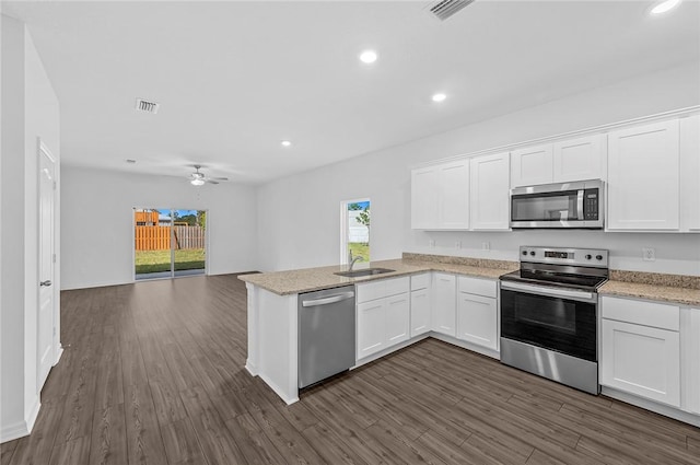 9316 104th Ave, Vero Beach, FL 32967 - kitchen featuring stainless steel appliances, a sink, a peninsula, open floor plan, and white cabinets