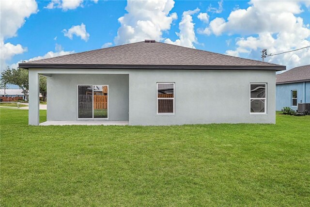 9316 104th Ave, Vero Beach, FL 32967 - back of house featuring a lawn, stucco siding, a patio area, and a shingled roof