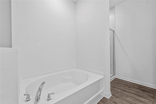 9316 104th Ave, Vero Beach, FL 32967 - bathroom featuring a bath, baseboards, a stall shower, and wood finished floors