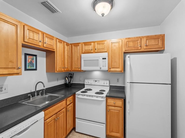 kitchen featuring white appliances, sink, and light tile patterned floors