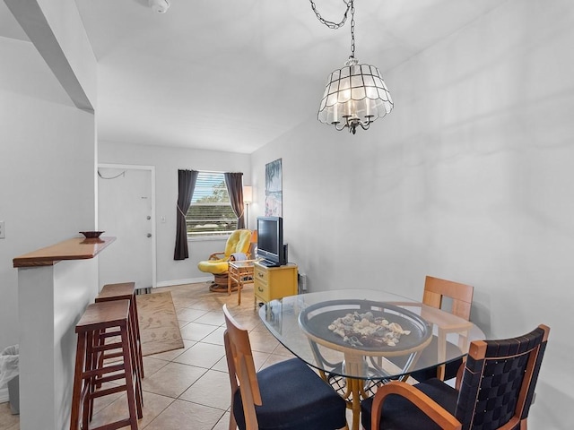 dining area with light tile patterned floors and an inviting chandelier