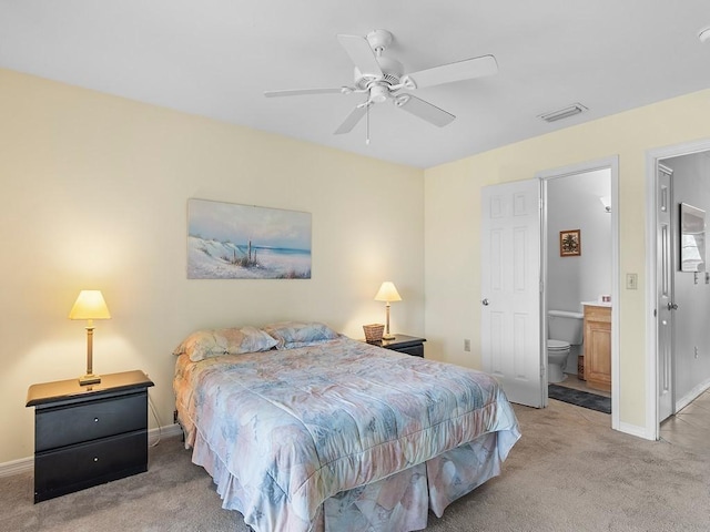 carpeted bedroom with ceiling fan and ensuite bath