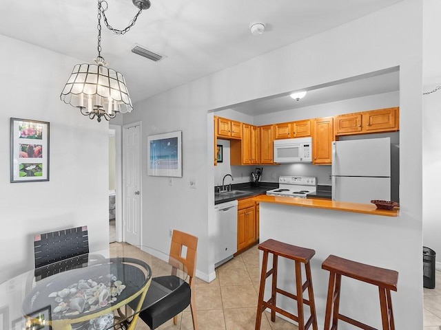 kitchen featuring sink, a chandelier, decorative light fixtures, white appliances, and light tile patterned floors