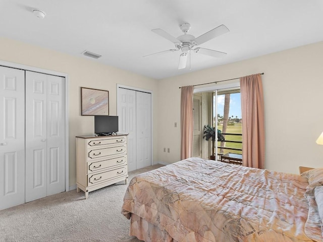 carpeted bedroom featuring ceiling fan and two closets