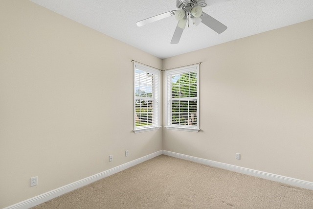 carpeted spare room with a textured ceiling and ceiling fan