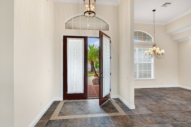 foyer with a high ceiling, a chandelier, and ornamental molding