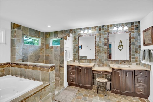 2410 47th Ter, Vero Beach, FL 32966 - bathroom with a whirlpool tub, vanity, tile walls, walk in shower, and tasteful backsplash