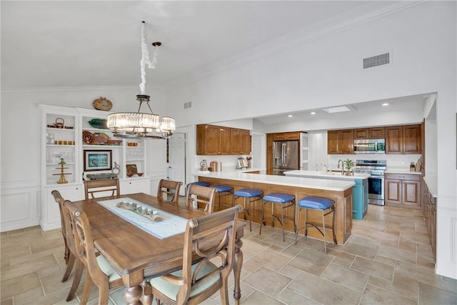 2410 47th Ter, Vero Beach, FL 32966 - dining space featuring a chandelier, crown molding, stone finish floors, and a high ceiling