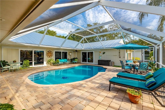 2410 47th Ter, Vero Beach, FL 32966 - swimming pool with a patio area, outdoor dining area, a ceiling fan, and glass enclosure