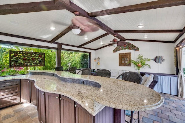 2410 47th Ter, Vero Beach, FL 32966 - kitchen with a breakfast bar area, a ceiling fan, light stone counters, wood ceiling, and stone tile floors
