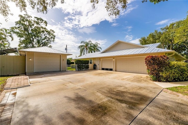 2410 47th Ter, Vero Beach, FL 32966 - view of front facade featuring a detached garage, a metal roof, and a gate