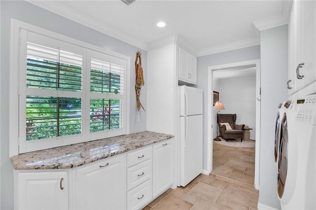 2410 47th Ter, Vero Beach, FL 32966 - kitchen featuring freestanding refrigerator, washing machine and clothes dryer, white cabinetry, ornamental molding, and light stone counters