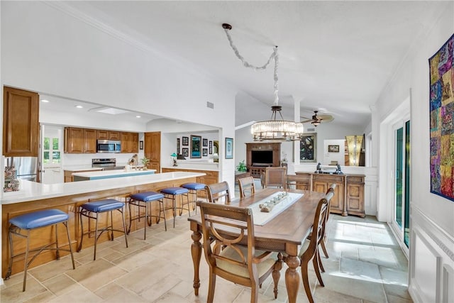 2410 47th Ter, Vero Beach, FL 32966 - dining space with a chandelier, vaulted ceiling, stone tile floors, ornamental molding, and recessed lighting