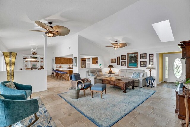2410 47th Ter, Vero Beach, FL 32966 - living room with a ceiling fan, vaulted ceiling, light stone finish floors, and a skylight