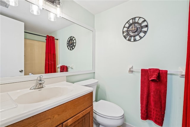 bathroom featuring curtained shower, toilet, and vanity