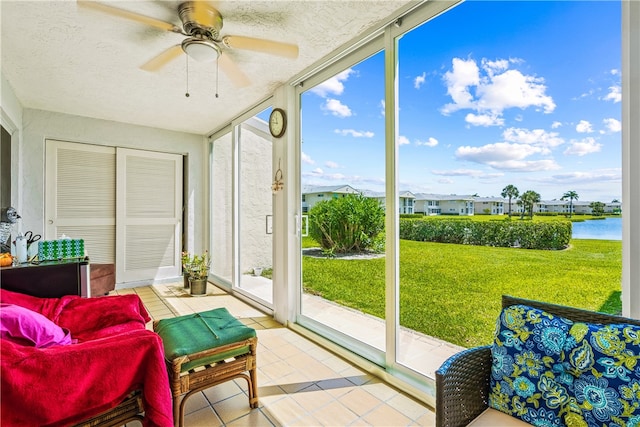 sunroom / solarium with ceiling fan, a wealth of natural light, and a water view